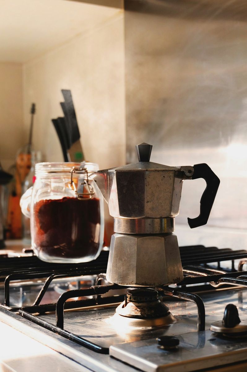 A moka pot on a gas stove burner